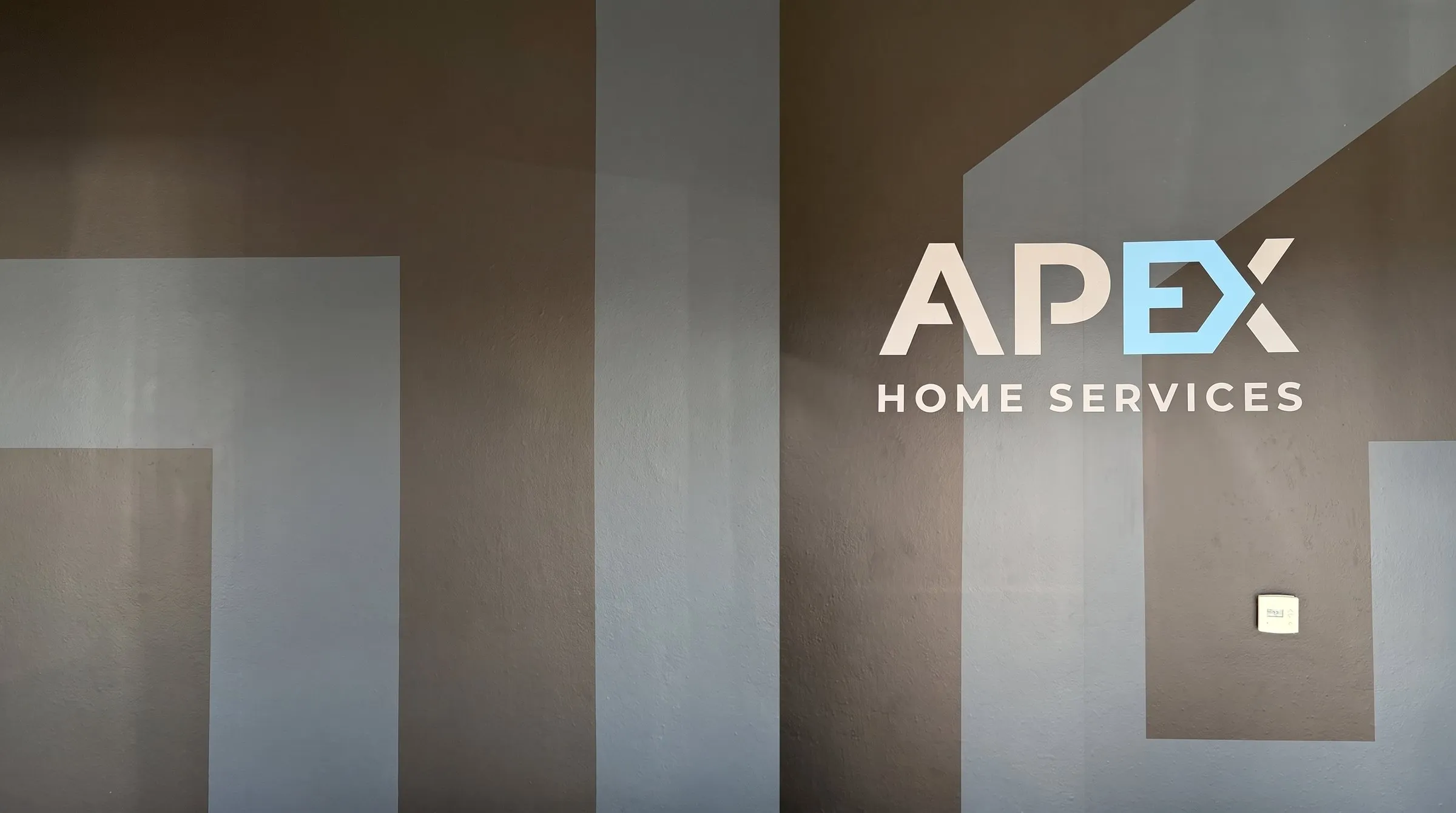 Apex Home Services logo on the office wall, about Apex Home Services, a Las Vegas restoration company