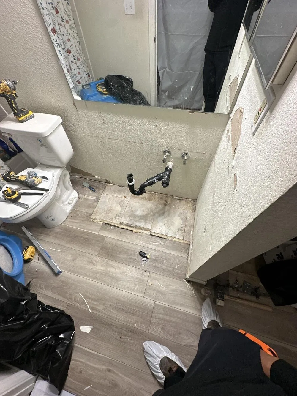 Bathroom with the vanity removed and the floor opened up, water damage repair from Apex Home Services in Las Vegas