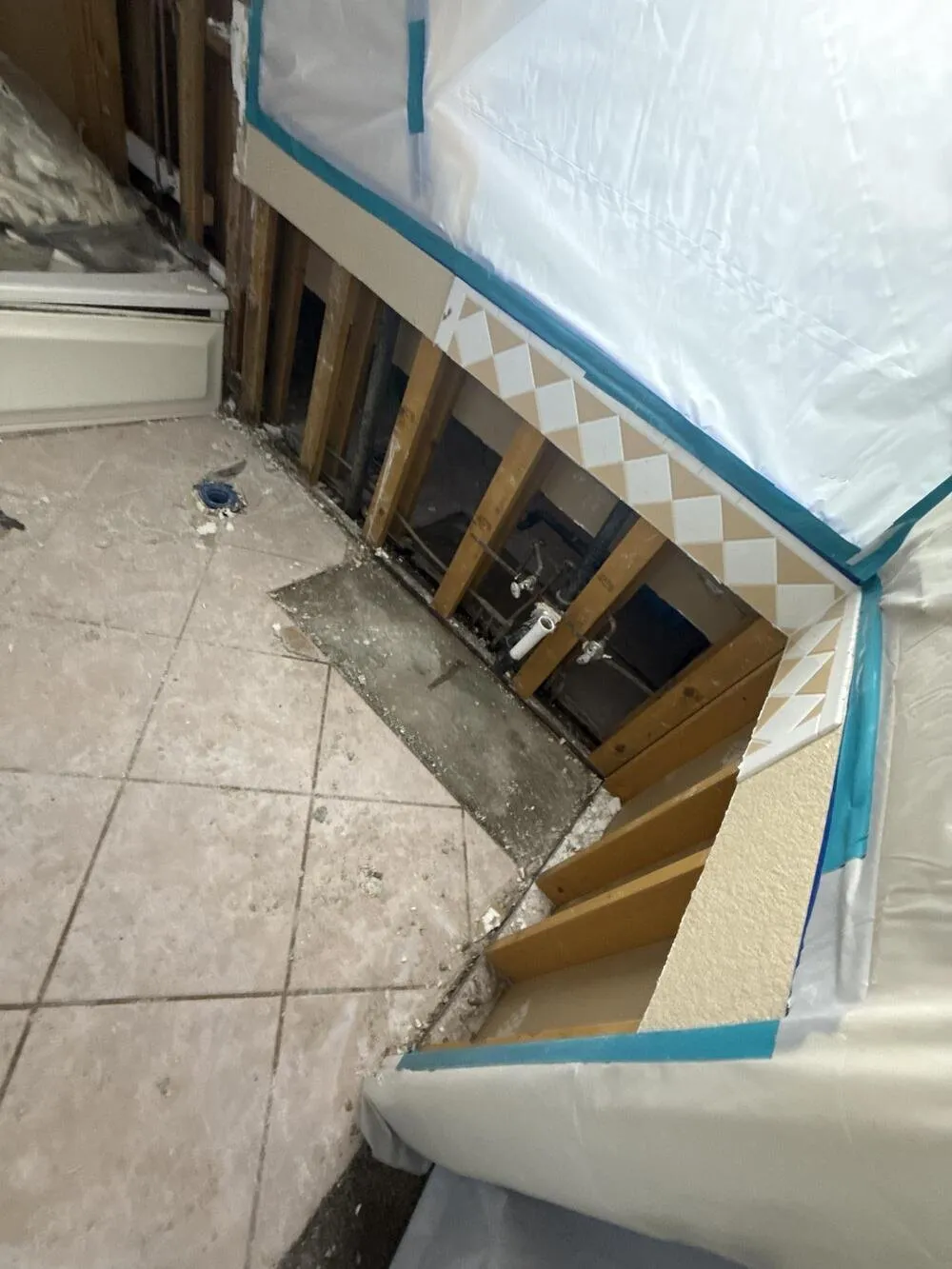 Bathroom wall cut open to the studs with plastic sheeting taped over the tub, lead abatement in Las Vegas