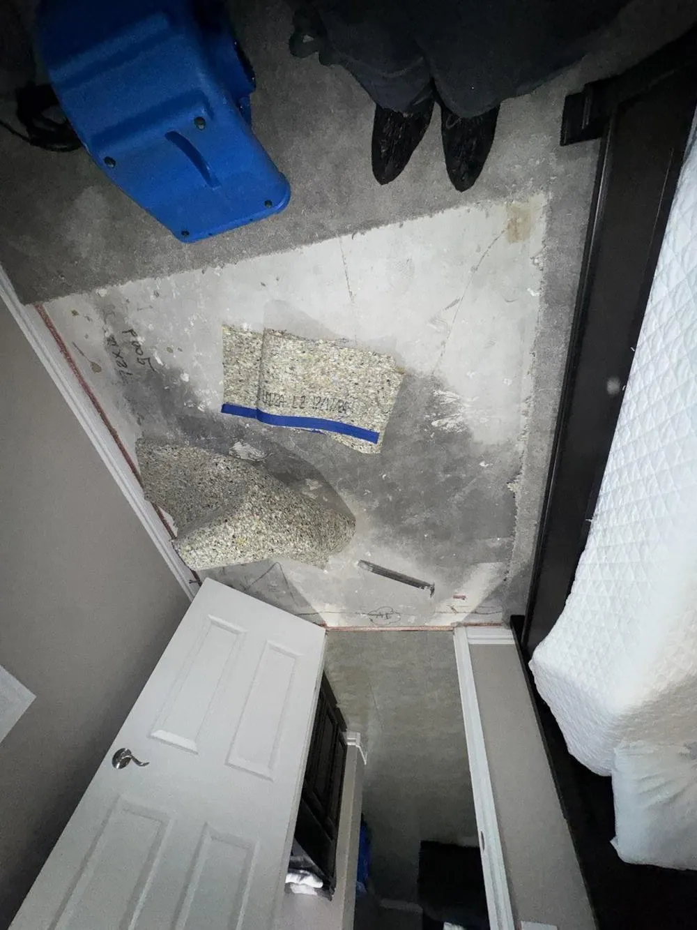 Bedroom with the carpet and pad pulled up and an air mover drying the slab, water damage restoration in Centennial Hills, NV
