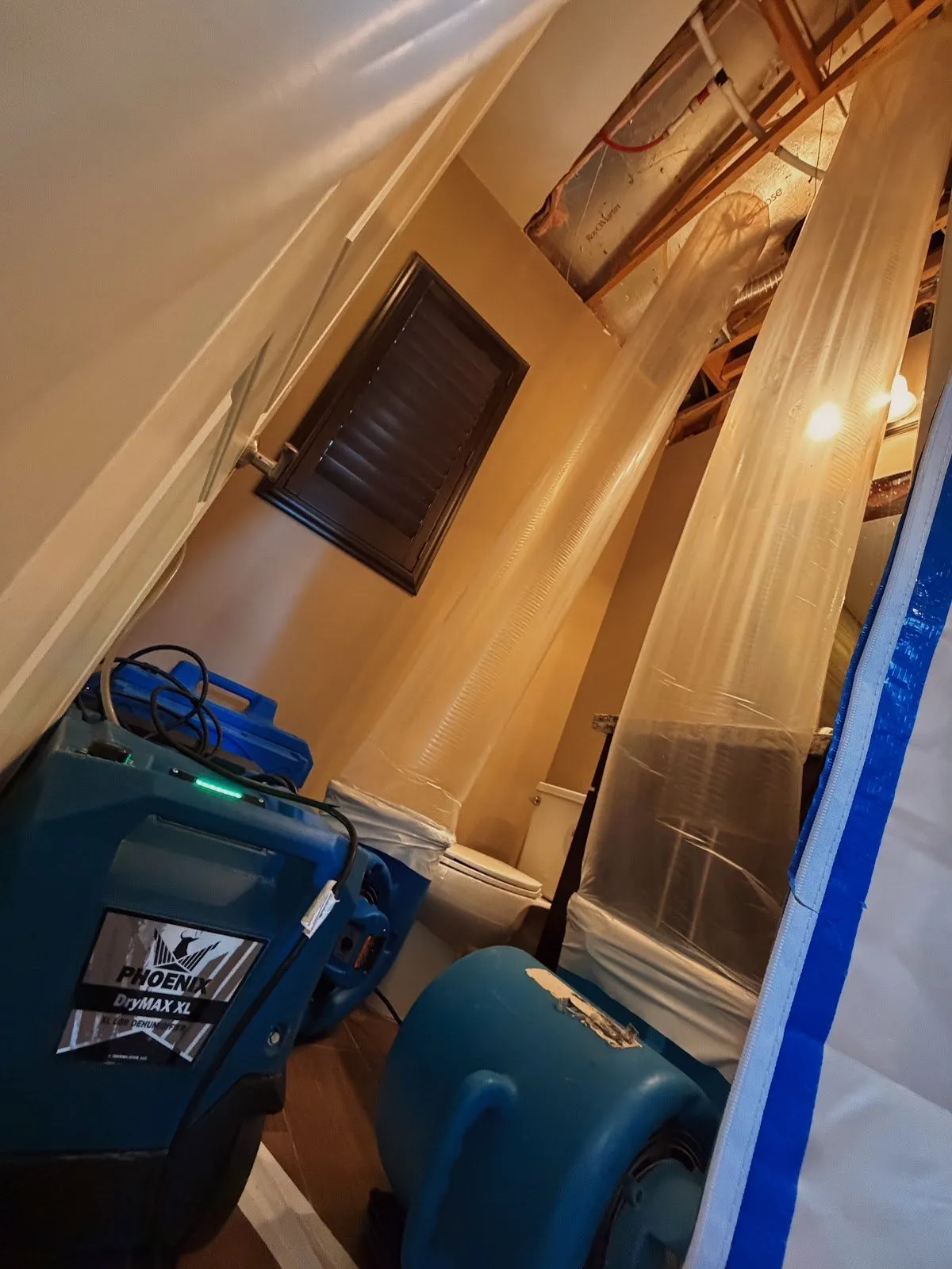 Dehumidifier and air movers running inside a plastic enclosure, flood cleanup in Las Vegas