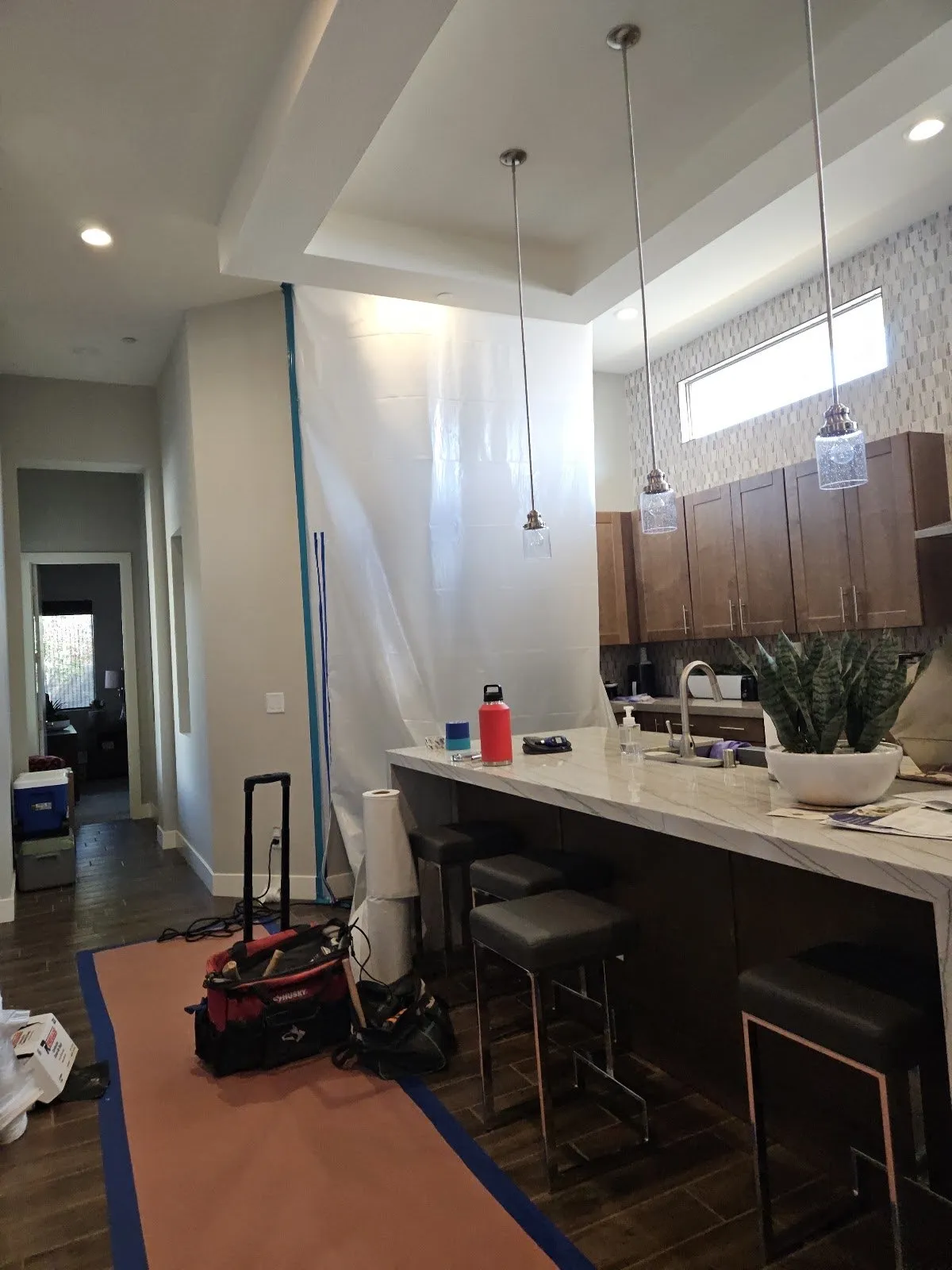 Kitchen with a plastic containment wall and the floor covered for protection, water damage restoration company in Las Vegas