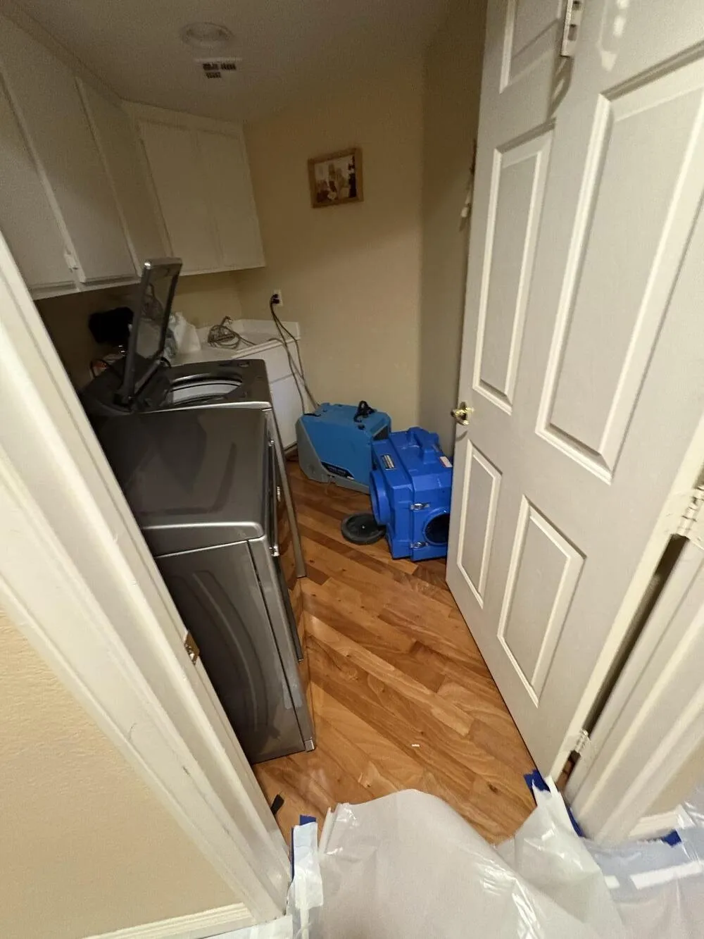 Dehumidifier and air mover drying a laundry room with wood flooring, water damage restoration in Enterprise, NV