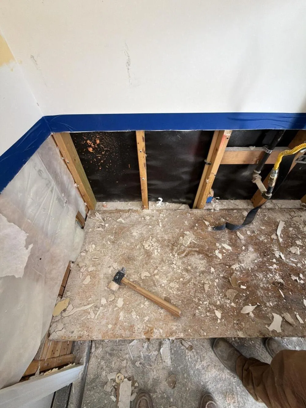 Wall opened to the studs with debris across the subfloor, lead abatement services in Las Vegas